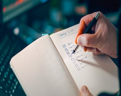 Person checking items on a simple handwritten list
